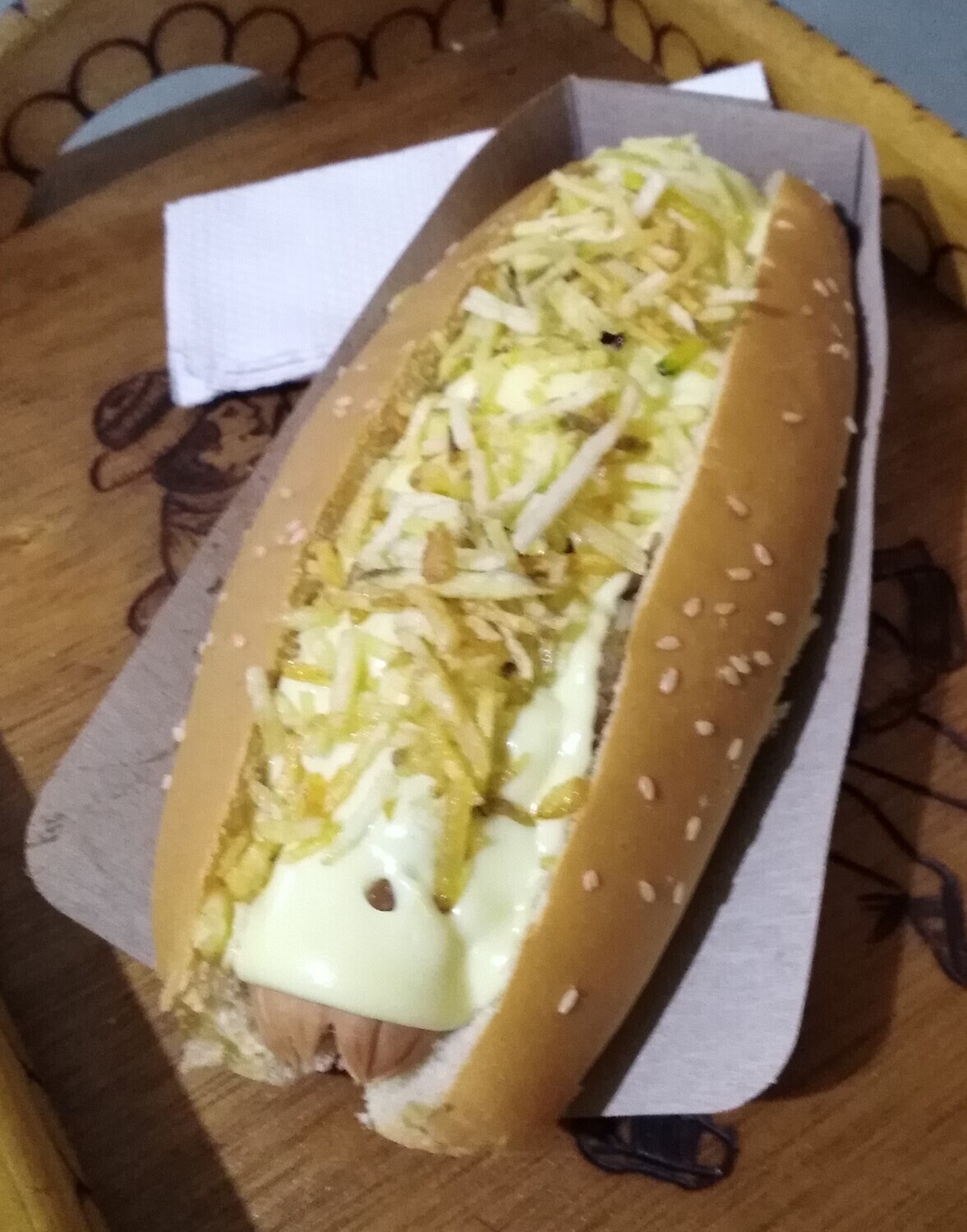 Super Perro Caliente  Zenu con queso, cebolla y papas callejeras. Salsas de tomate, bbq, tártara, mayonesa y mostacream. Salsa artesanal de piña, opcional.