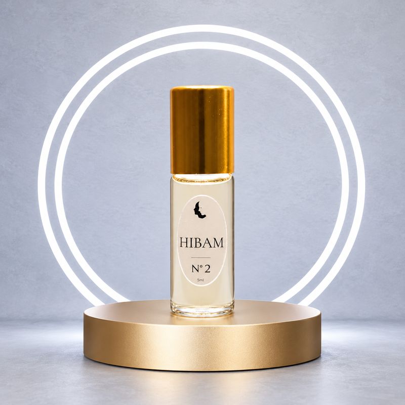 HIBAM N°2 Eau de Parfum im 5-ml-Roll-on mit goldener Verschlusskappe auf einem Goldpodest vor weißen Lichtkreisen.