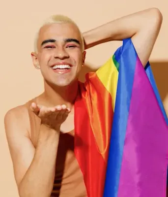 Entdecke unsere Top-Angebote! Junger Mann mit Regenbogenflagge lächelt und überreicht ein Top-Angebot. Jetzt zugreifen und sparen!