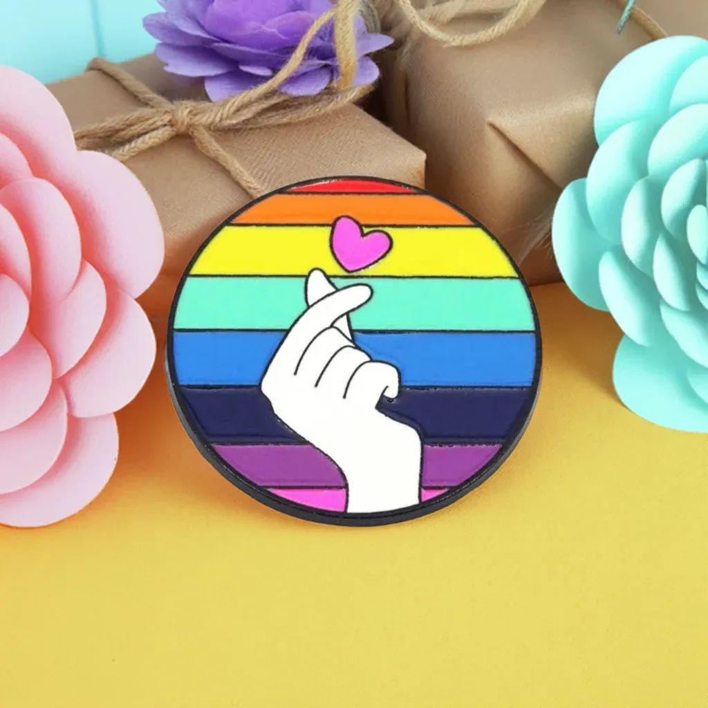 Regenbogen Fingerherz Anstecknadel: Brüniertes Metall Pride Pin mit Hand Herz Motiv in LGBTQ+ Regenbogenfarben. Bild 1