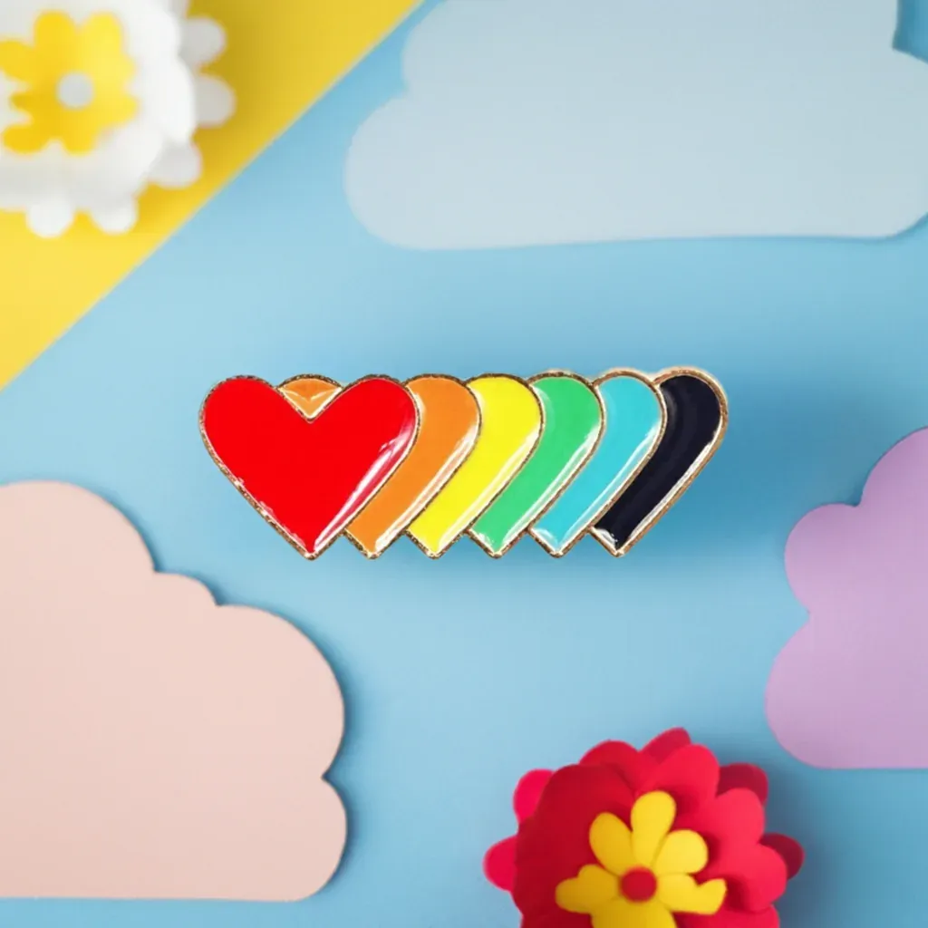 Regenbogen Herzen Anstecknadel: Messing Pride Pin mit 6 bunten Herzen in LGBTQ+ Regenbogenfarben, Pride Accessoire. Genderella Pride Shop. Bild 1