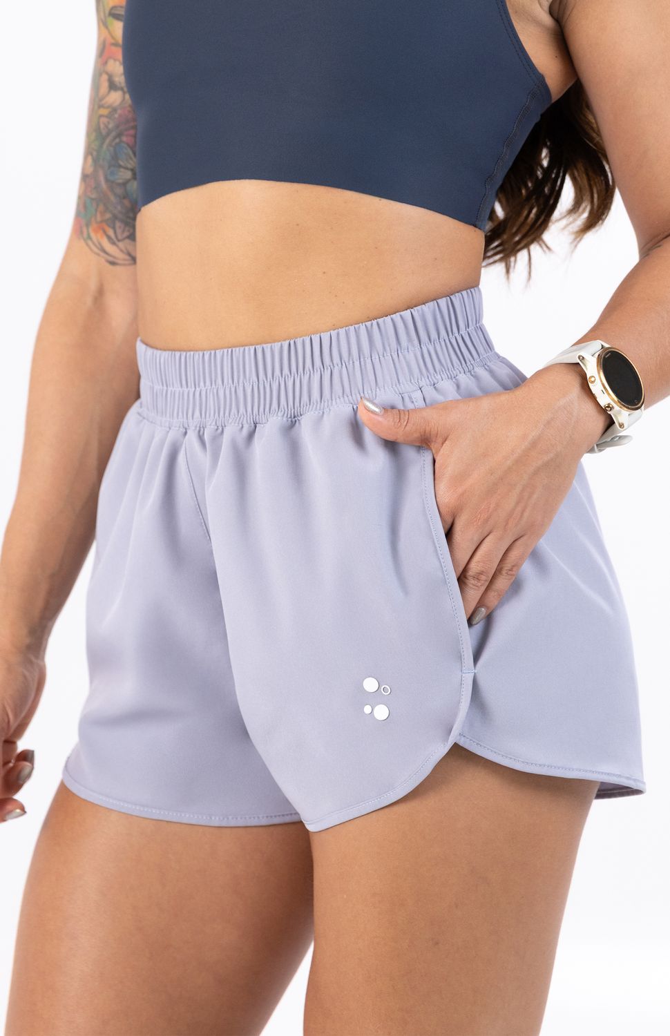 El nuevo Short Deportivo Highforce para mujer. Diseñado con una silueta fluida de bordes curvos redondeados que estilizan la figura y optimizan la apertura de la zancada, este short incorpora una cómoda pretina elástica fruncida de tiro medio-alto que garantiza un ajuste seguro y adaptable en la cintura durante tus rutinas de running, funcional o gimnasio.
Su pilar tecnológico es un avanzado tejido antifluido de rápido secado, que actúa como una barrera protectora repeliendo salpicaduras y lloviznas ligeras, mientras evapora la humedad corporal en tiempo récord para mantenerte ligera y seca. Equipado con prácticos bolsillos laterales, te ofrece el espacio ideal para guardar tus esenciales con total comodidad, fusionando un look de tendencia urbana con el máximo rendimiento técnico.
Beneficios Clave:
•	Tecnología Antifluido Avanzada: Escudo textil de alta ingeniería que repele líquidos y humedad externa para entrenar sin límites al aire libre.
•	Bolsillos Laterales Funcionales: Almacenamiento seguro y accesible para tus llaves, tarjetas o geles durante la carrera.
•	Secado Rápido y Ligereza: Material de peso mínimo que no acumula agua ni sudor, evitando el roce y manteniendo la frescura de principio a fin.
•	Diseño Curvo Ergonómico: Cortes laterales redondeados que favorecen la libertad total de movimiento y aportan una estética atlética sofisticada.
 
 
 60000 
 true 
 765474163,574087863,573463925
