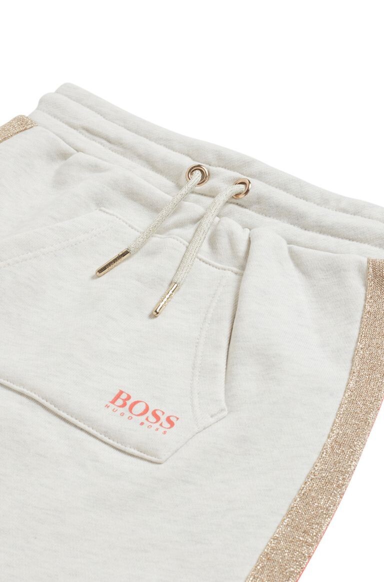 Hugo boss Girls beige skirt with a gold and a white stripe down the side and a pocket in the front J13101 – C19