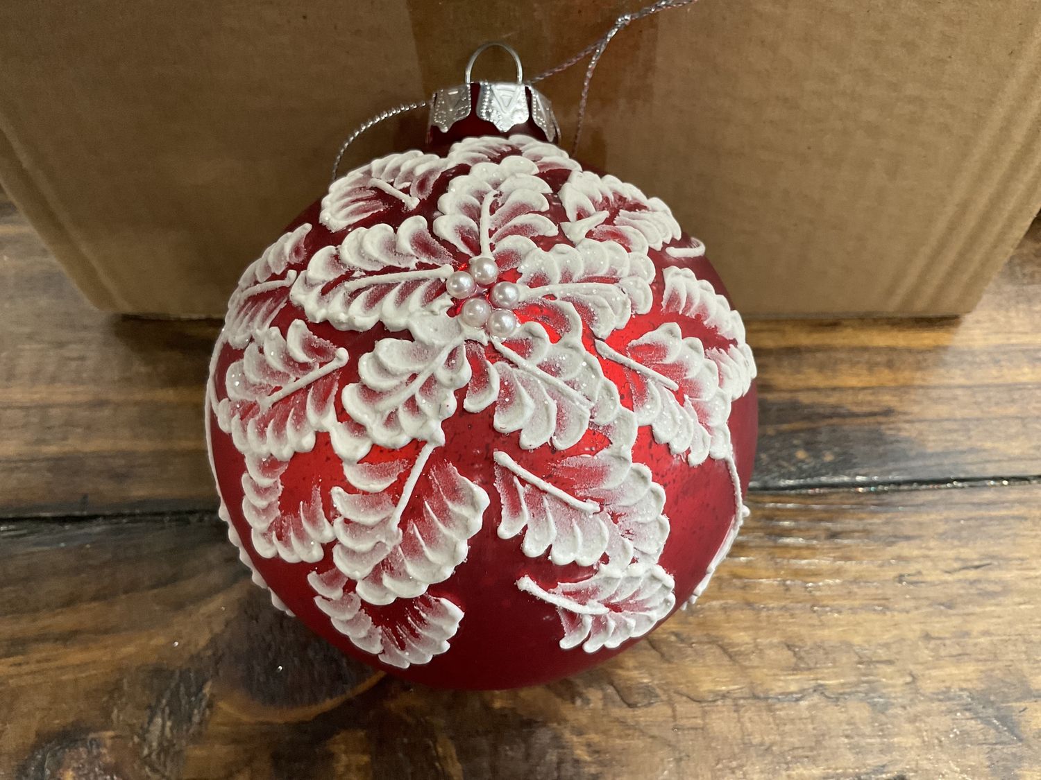 White painted flower ornament on red