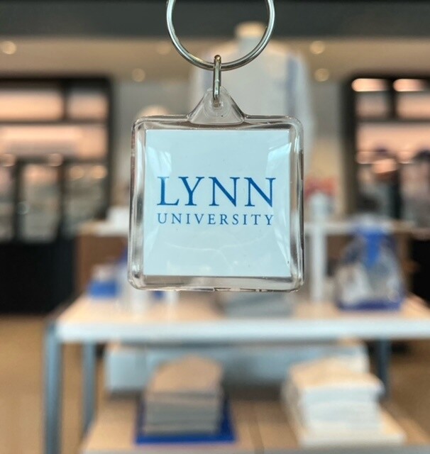 Clear key ring with white interior and blue text saying &quot;Lynn University.&quot;