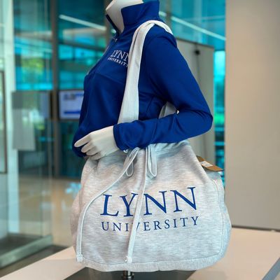 white beach bag with blue lettering saying &quot;Lynn University.&quot;