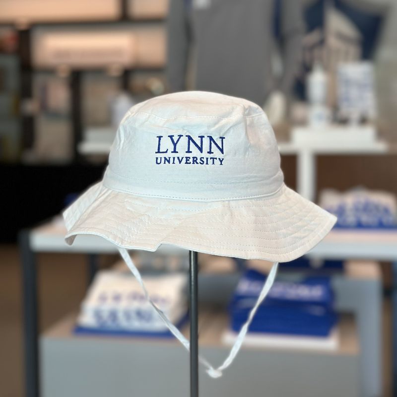 white bucket hat with blue lettering saying &quot;Lynn University.&quot;