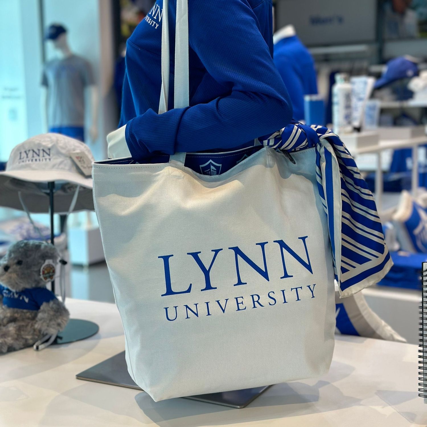 reversible canvas tote, the outside is white with blue lettering saying &quot;Lynn University&quot; and the inside is mostly royal blue, with white throughout and multiple spirit logos.