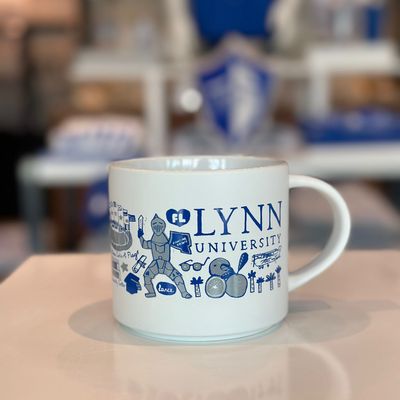 White mug with blue Lynn logos surrounding the cup and blue text saying &quot;Lynn University.&quot;