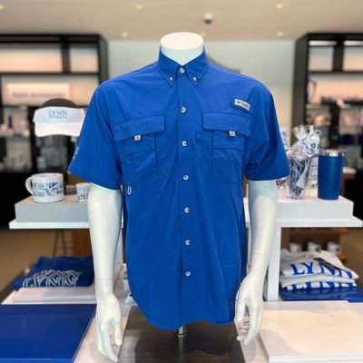Royal blue short sleeve collared, button up shirt, with a pocket on each side of the chest and white lettering on the right sleeve saying &quot;Lynn University.&quot;