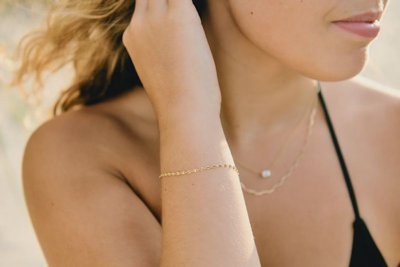 The Lanikai Moonrise Bracelet by Cove Fine Jewelry is a delicate and elegant piece that features a fine gold chain. 