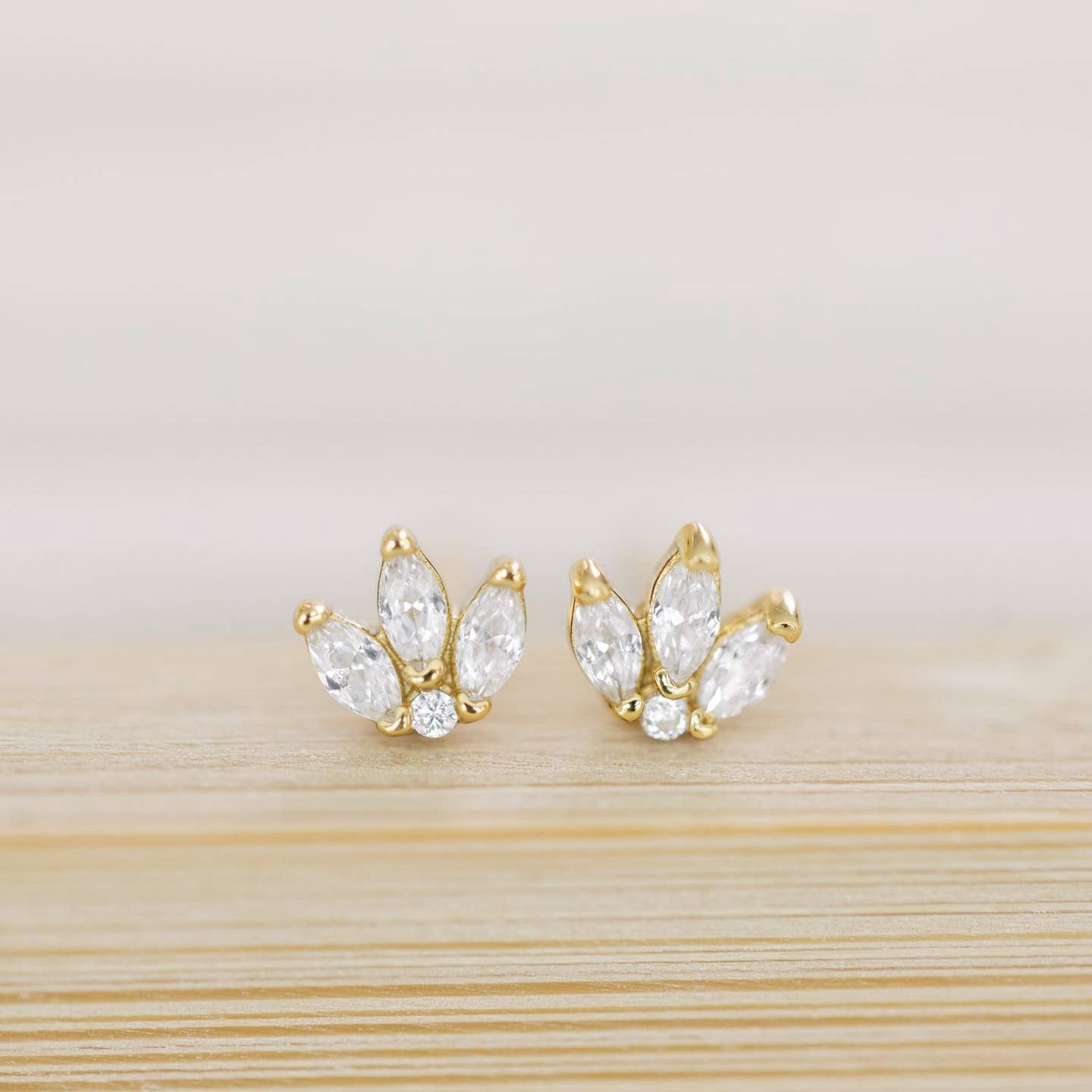 The Coast and Cove Crystal Flower Studs are elegant, delicate earrings featuring a floral design adorned with sparkling crystals.