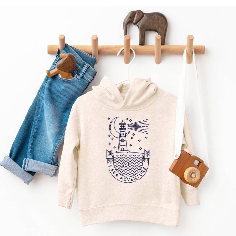 The Sea Adventure Kids Hoodie by Spruce Seed is a cozy, unisex fleece pullover designed for little explorers. Featuring a beach coastal theme with a lighthouse and ocean coast design, this hoodie captures the spirit of seaside adventures. 