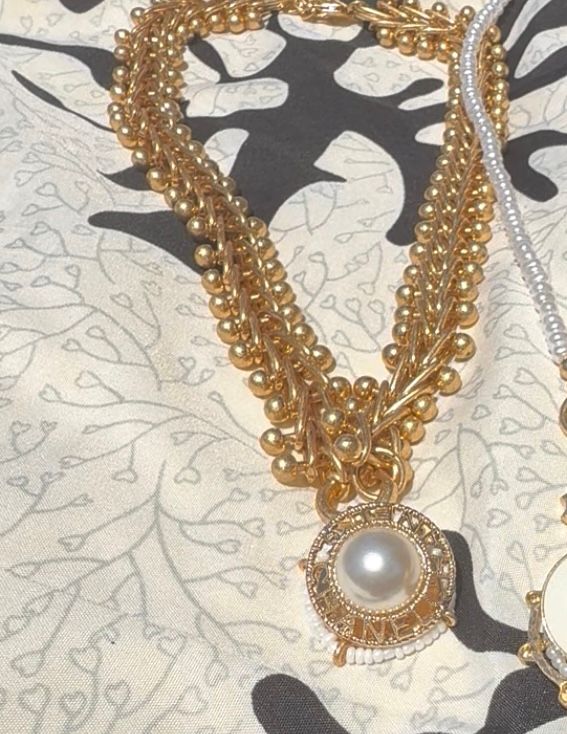 Stylish gold tone necklace with button charm