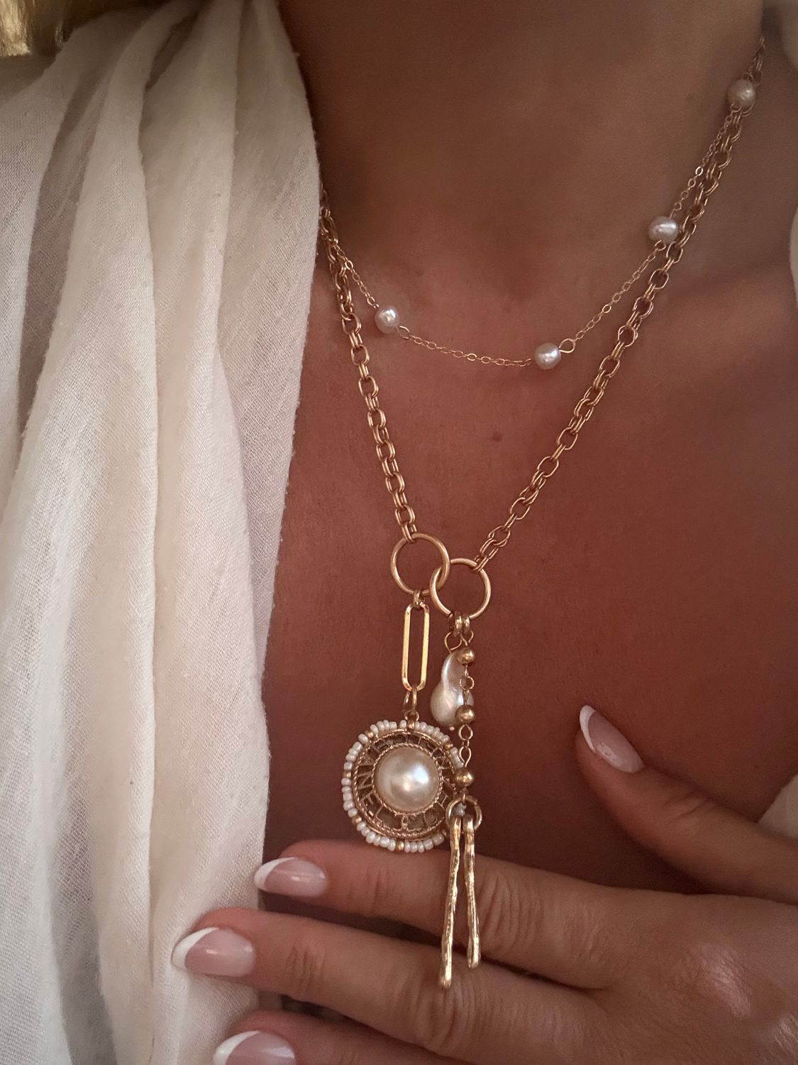 Delicate gold tone necklace with pearl button charm