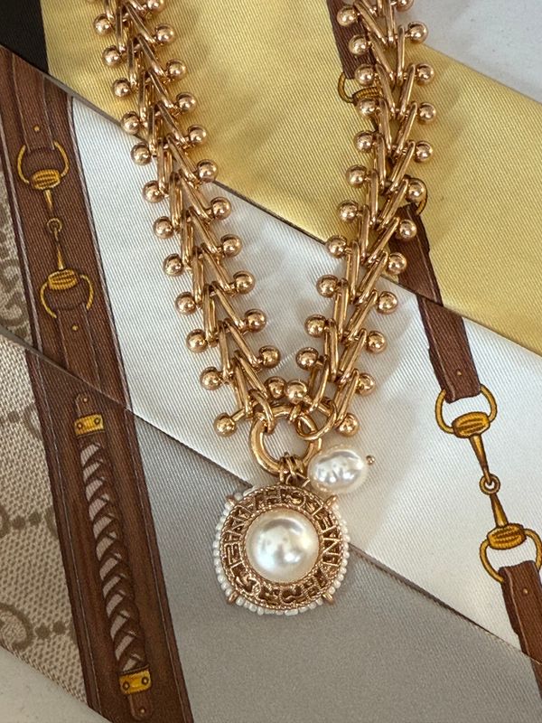 Stylish gold tone necklace with button charm