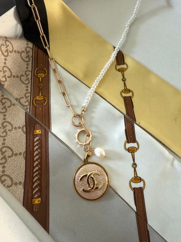 Elegant gold tone necklace with charn