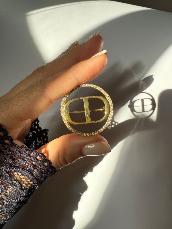 Delicate round logo brooch with rhinestones