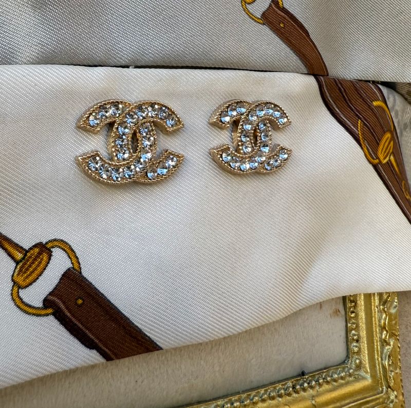 Delicate gold earrings with rhinestones logo