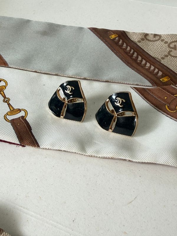 Timeless stud earrings featuring glossy black enamel and refined gold-tone details