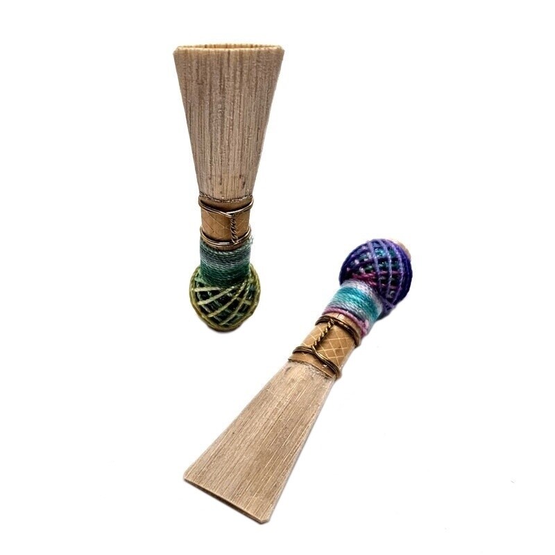 One bassoon reed standing on end and one laying down