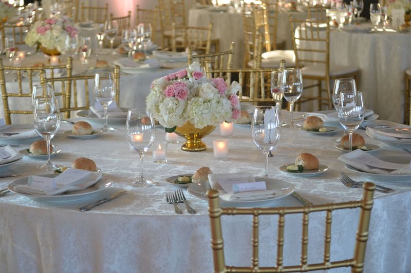 a fresh flower wedding reception centerpiece in a gold compote with white hydrangeas and pink roses from cape may florist
