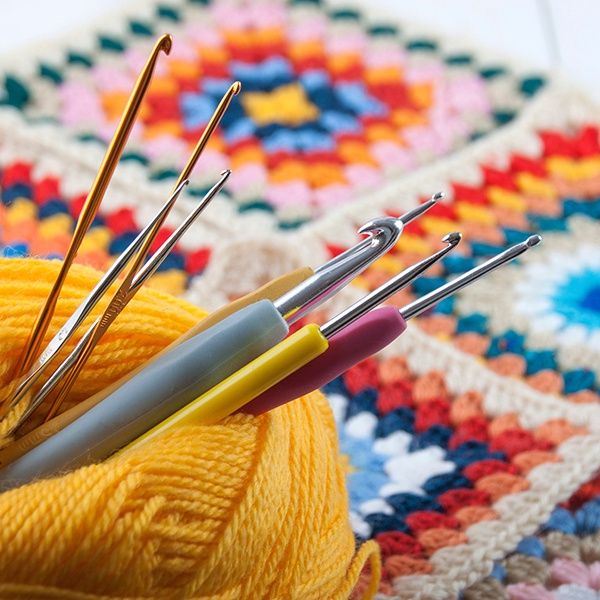 crochet hooks with yarn and granny squares