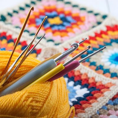 crochet hooks with yarn and granny squares