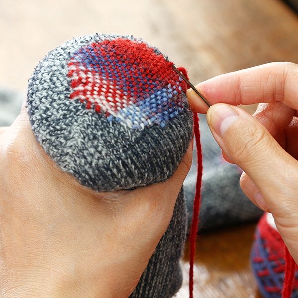 Darning a sock with yarn and a needle