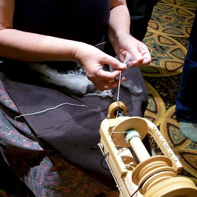 spinning 102 class, hands demonstrating spinning wool on a spinning wheel