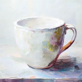 Weiße Keramiktasse, vor grau weißem Hintergrund.