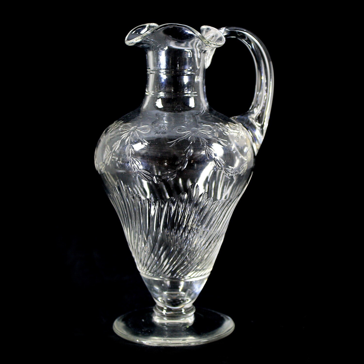 Handle jug made of colorless crystal glass with fluting and bows around 1910