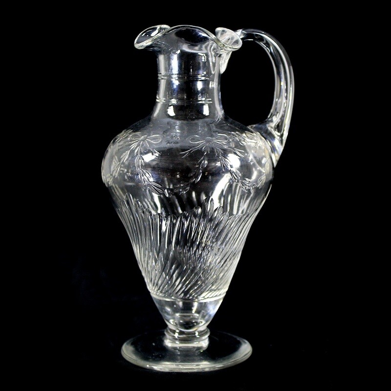 Handle jug made of colorless crystal glass with fluting and bows around 1910