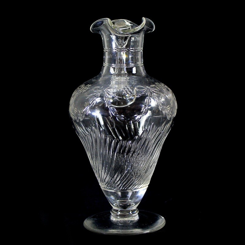 Handle jug made of colorless crystal glass with fluting and bows around 1910