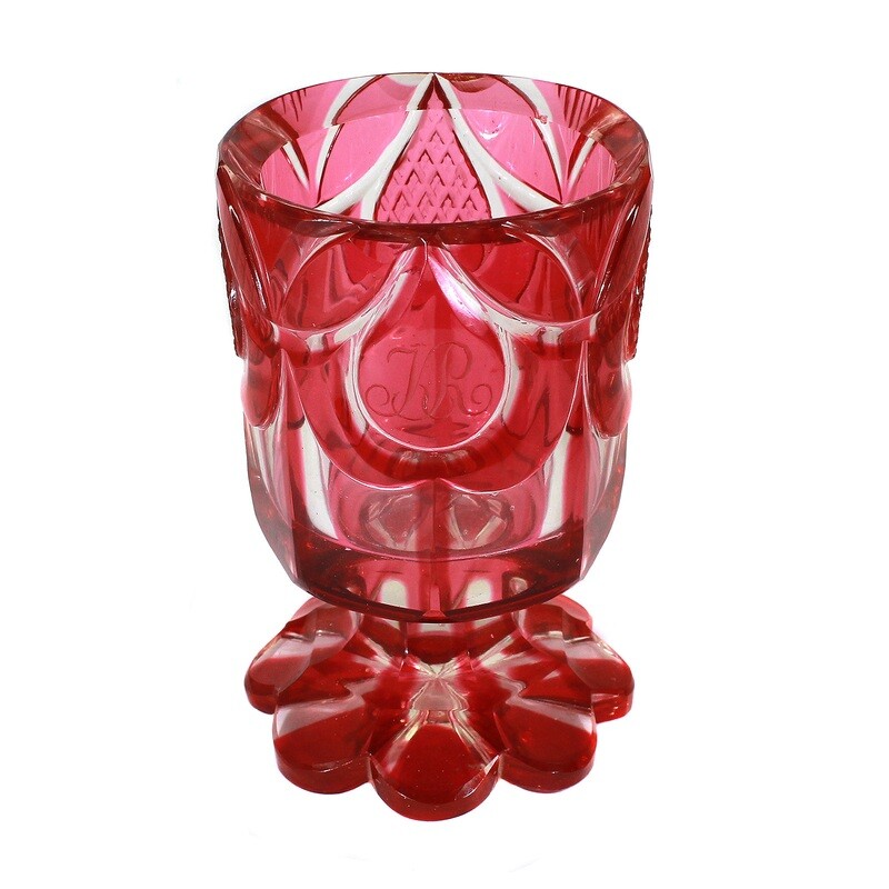 Heavy footed cup made of colorless glass with gold ruby overlay around 1835