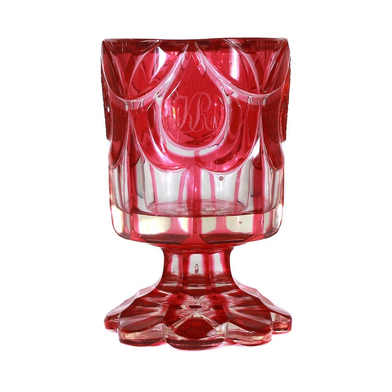 Heavy footed cup made of colorless glass with gold ruby overlay around 1835