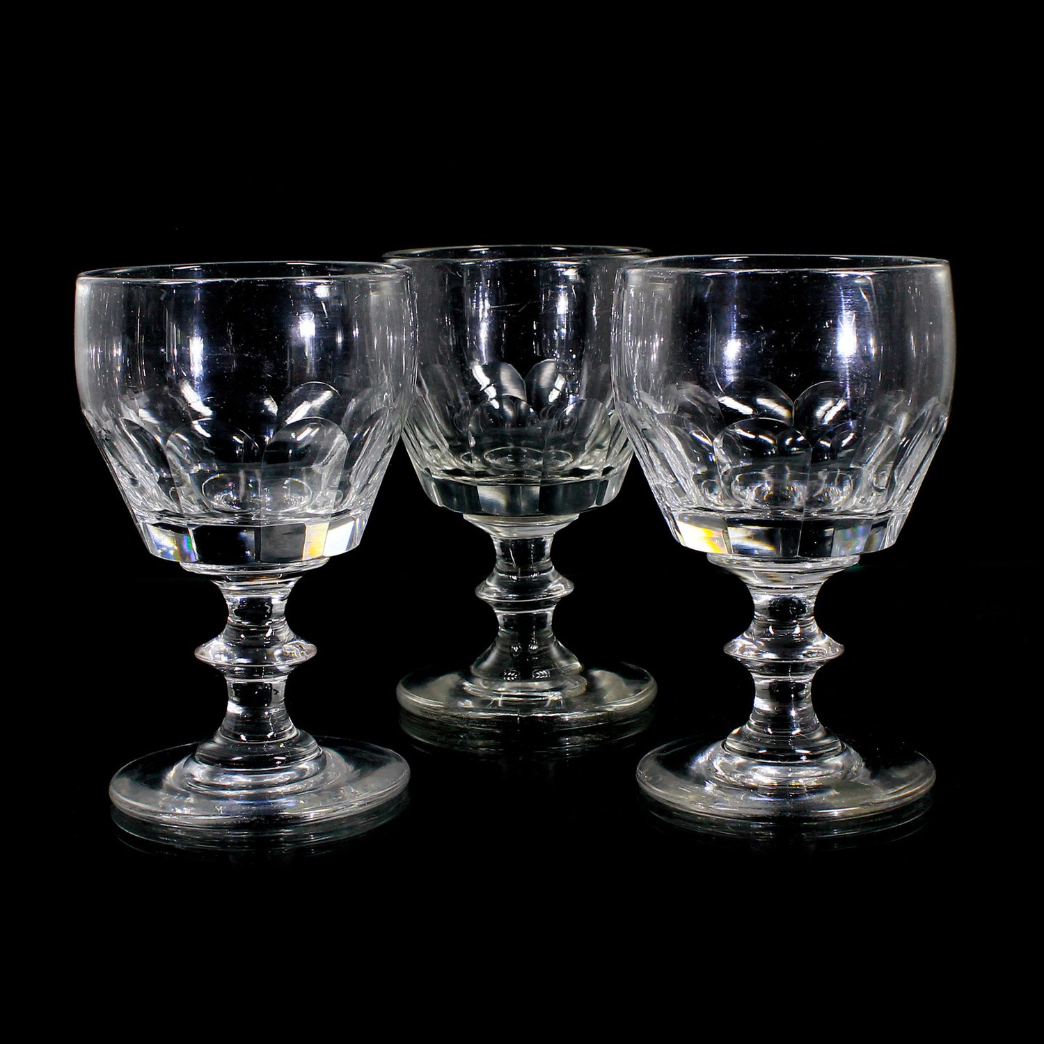 3 goblets made of colorless glass with curved facets and a pressed nodule, mid-19th century.