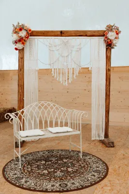 Handgeknüpfter Makramee-Traubogen im Boho-Stil auf Holzstab, geeignet für Hochzeiten und freie Trauungen in der Schweiz