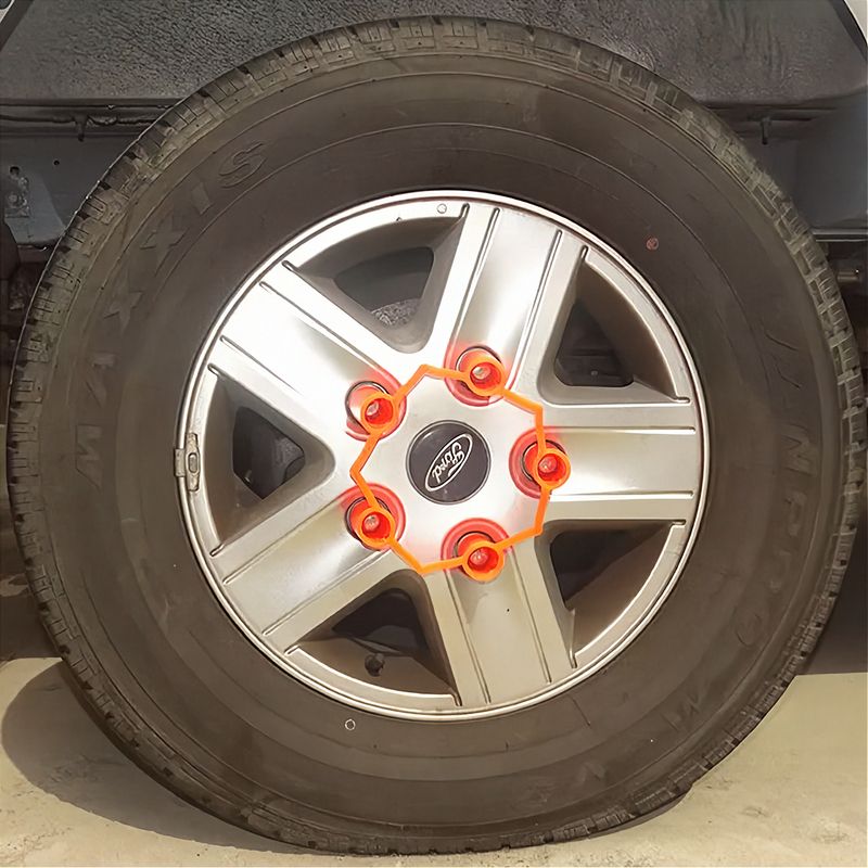 A 5-stud wheel with a fluoro orange long-barrelled wheel nut locker installed