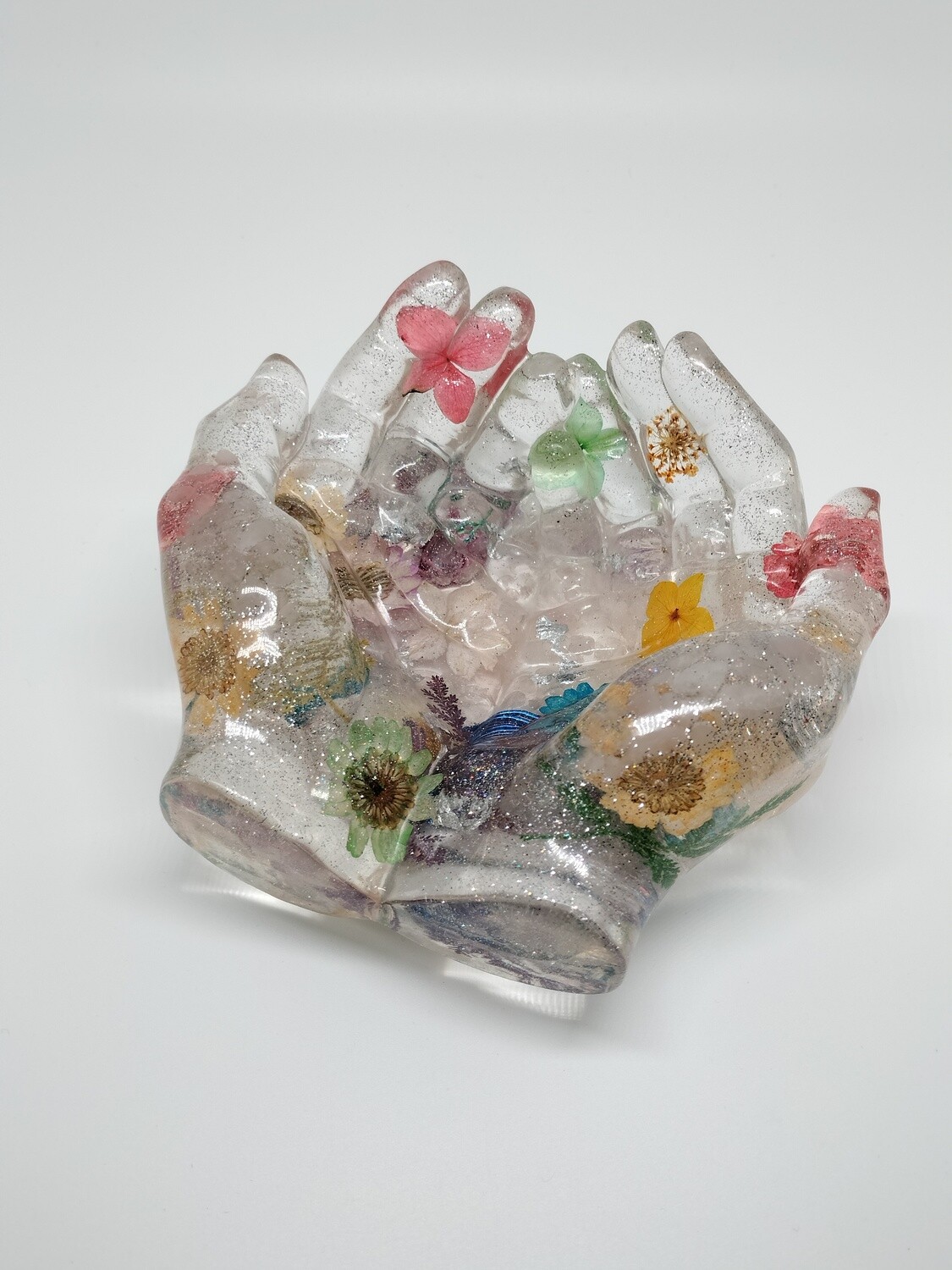 Orgonite handen met bloemen in chakra kleuren