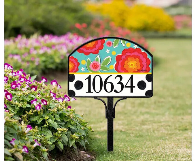 Magnetic yard sign featuring bright, colorful flowers and address numbers, installed in a garden.