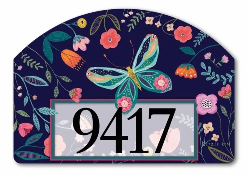 Close-up of magnetic yard sign featuring a colorful butterfly, flowers, and adhesive address numbers.