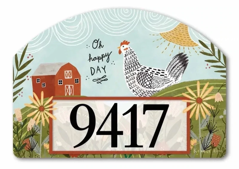 Close-up of magnetic yard sign with a rooster, sunflowers, barn, and adhesive address numbers.