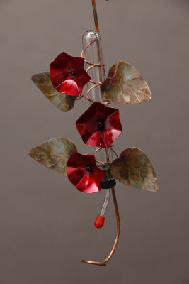 Close-up of the red morning glory floral accents and weathered metal leaves on the copper feeder.