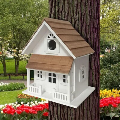 Side view of the white cottage birdhouse showing decorative window trim and the paddle-board mount.