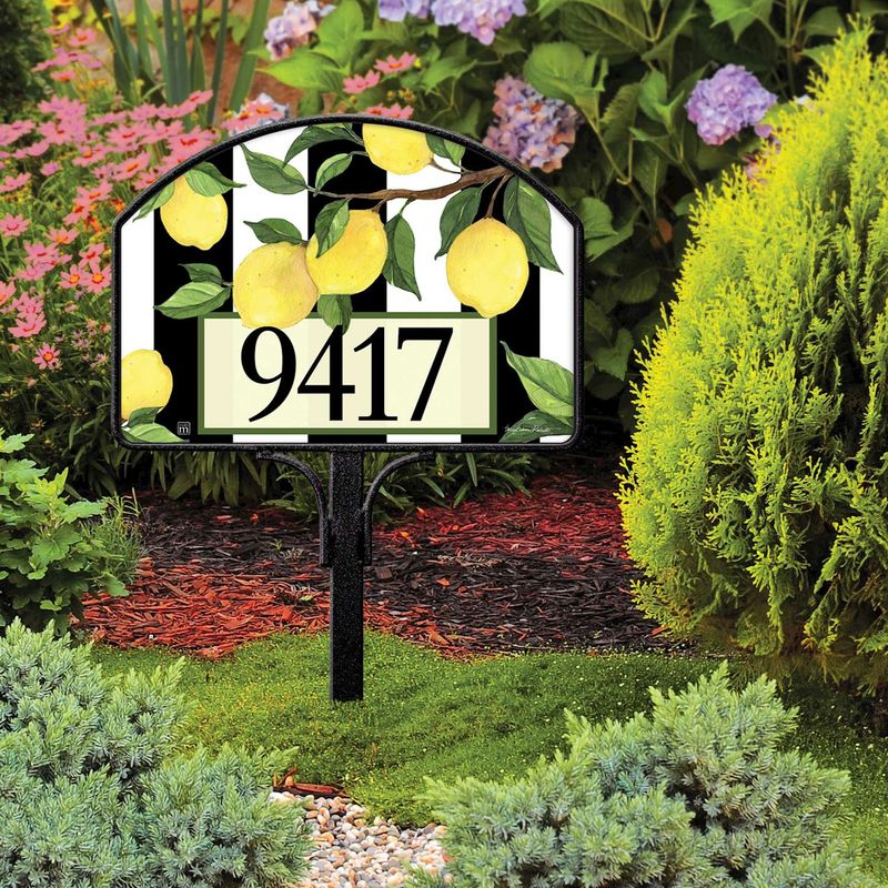 Magnetic yard sign featuring yellow lemons and address numbers, installed in a green garden setting.