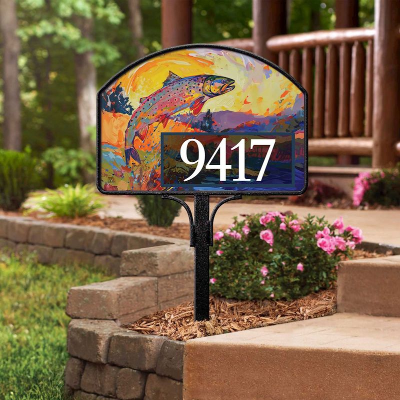Magnetic yard sign featuring a jumping trout and address numbers, installed on a metal stake in a garden.
