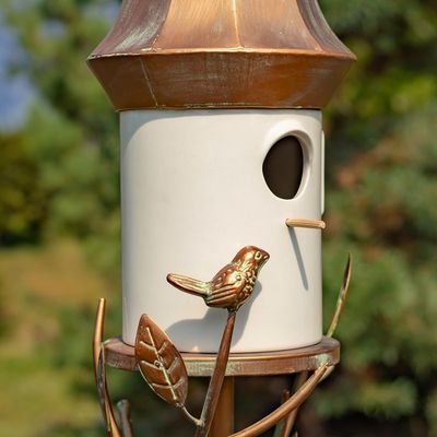 Close-up of the white porcelain body showing the 1.75-inch entry hole and a small decorative iron bird perched.