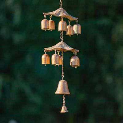 Detail of the two-tier mushroom-inspired wind chimes hanging from the iron birdhouse.