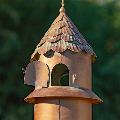 Close-up of the leaf-patterned copper roof and integrated mesh bird seed feeder.